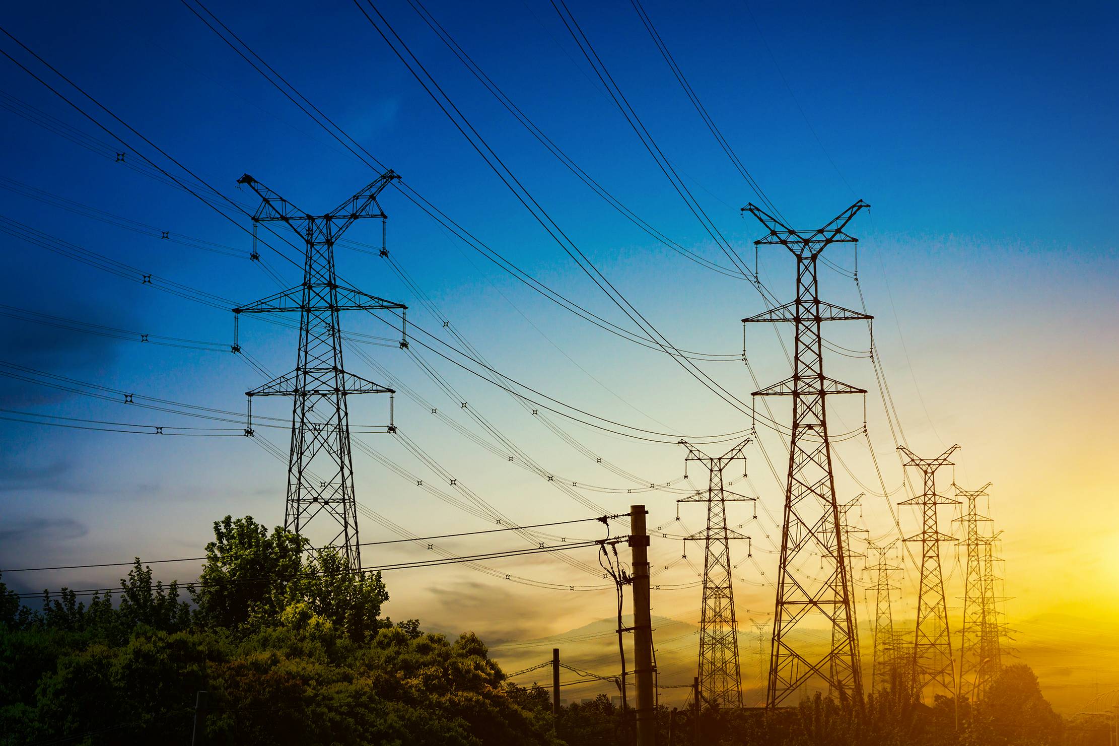 Sun setting silhouette electricity pylons